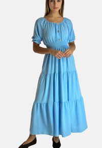 Jasnoniebieska maxi sukienka z marszczonym pasem, krótkimi bufiastymi rękawami oraz detalem z guzików, wykonana z warstwowej, fakturowanej tkaniny.
