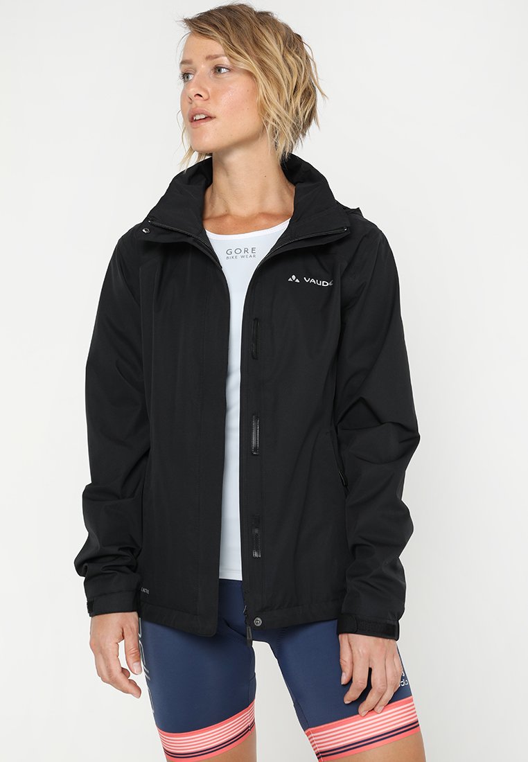 Black waterproof jacket with a zip front, adjustable hood, and elastic cuffs. Paired with blue shorts featuring red stripes at the hem.