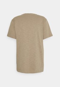 Beige t-shirt med kort ärm och rund halsringning. Tyget verkar mjukt med en subtil textur, har en avslappnad passform och inga synliga mönster eller logotyper.