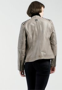 Graue Lederjacke mit genieten Schulterakzenten und Reißverschlussärmeln, mit einer enganliegenden Passform und glatter Textur. Rückansicht gezeigt.