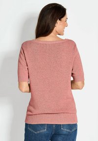 Roze gebreide trui met korte mouwen, ronde hals en geribbelde zoom. De textuur lijkt zacht en geschikt voor casual draag.