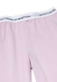 Hellrosa Leggings aus weichem Stoff, mit elastischem Bund, auf dem "UNITED COLORS OF BENETTON" schwarz gedruckt ist. Nahtloses Seitendetail.