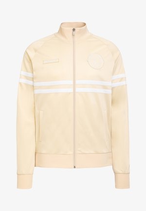 Cremefarbene Reißverschlussjacke mit weißen Streifen über der Brust und den Ärmeln, gerippten Bündchen und Taschen. Auf der oberen linken Seite befindet sich ein rundes Logo.