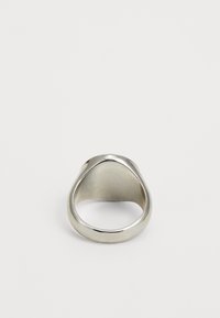 Anel de metal prateado com um design liso e arredondado. Apresenta uma forma afilada e um acabamento polido, com um interior oco.