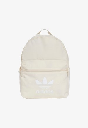 Zaino beige chiaro con cerniera bianca e logo Adidas. Forma rotonda, materiale in tessuto, scomparto unico e tasca frontale.