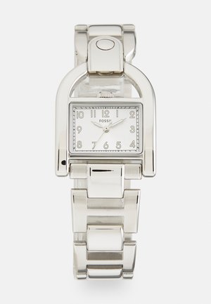 Silberner Edelstahl-Uhr mit quadratischem Ziffernblatt, weißem Ziffernblatt, schwarzen Ziffern und einem Linked-Armband Design. Verfügt über einen Schnappverschluss.