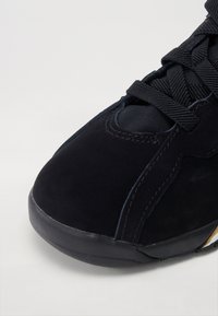 Melna zamšāda sneaker ar noapaļotu purngalu, teksturētām auklām un smalkām šuvēm. Mīksts augšdaļas materiāls ar izturīgu gumijas zoli.