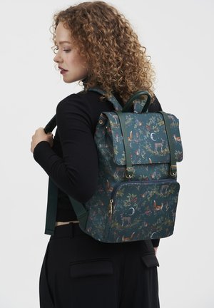 Mochila verde con un diseño estampado que presenta animales y follaje, fabricada con material duradero, con un bolsillo con cremallera en la parte frontal y correas ajustables.