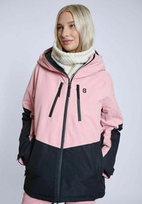 Lyserød og sort vandtæt jakke med hætte, udstyret med lynlåslukning, to forreste lommer og tekstureret stof nær kraven.