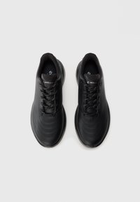 Pair of black athletic shoes with laces, viewed from above on a plain light background.