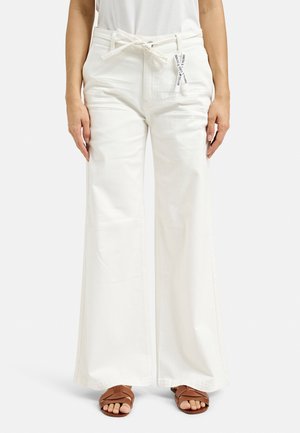 White wide-leg pants with a drawstring waist. Made of soft fabric, featuring a smooth texture and pockets on the side. Brown sandals are worn.