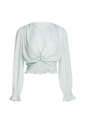 Long-sleeve light blue blouse with V-neck, twisted front detail, smocked waist and cuffs, and ruffled edges on sleeves and hem.