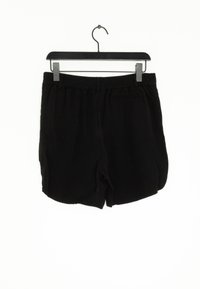 Svarta shorts hängande på en svart hängare med resårmidja. Tillverkade av ett slätt tyg, med sidofickor och en avslappnad passform.