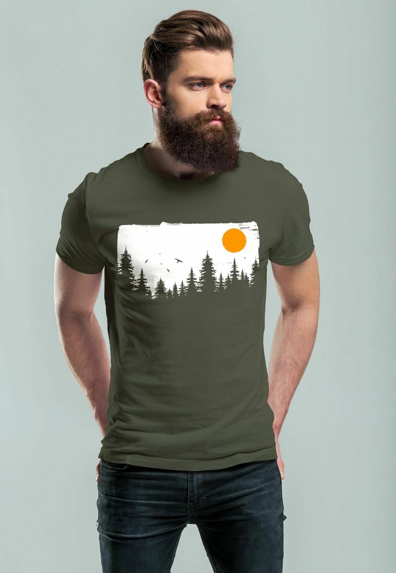 Olive green T-shirt with a white and black tree silhouette graphic, featuring an orange sun and birds. Slim fit, soft material, crew neck design.