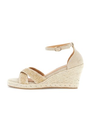 Beige kile-sandal med vævede krydsremme foran og ankelrem med spænde på jute-textureret platforms-hel.