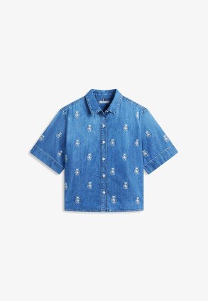 Blauw denim overhemd met korte mouwen, knoopsluiting en geborduurde ronde wapenschilden met kroontjes, gelijkmatig verdeeld over de stof.