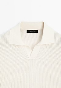 Polo en maille crème avec des rayures verticales texturées et une étiquette noire Massimo Dutti à l’intérieur du col.