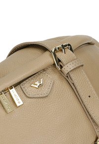 Borsa a tracolla in pelle beige con superficie testurizzata, hardware dorato, tracolla regolabile e etichetta decorativa sulla zip.