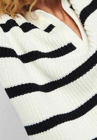 Gestreiftes Schwarz- und Weißes Sweatshirt aus strukturiertem Strickstoff, mit V-Ausschnitt und breiten horizontalen Streifen.