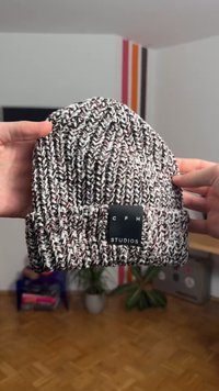 Hallidest, valgetest ja bordoopunastest toonidest kootud müts. Omaduseks sooniline tekstuur ja must silt, millel on voldil tikitud kiri "CPH STUDIOS".