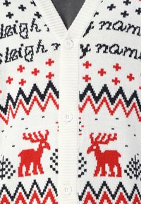 Hvid strikket cardigan med røde og sorte rensdyr- og geometriske mønstre, V-hals, knaplukning og tekstureret stof.