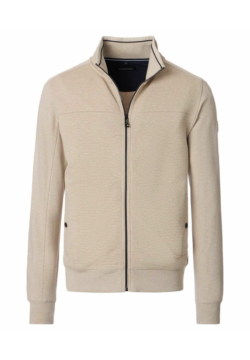 Beige ritsjack met een gestructureerd oppervlak, staande kraag en zwarte accenten. Voorzien van zijzakken en geribbelde manchetten aan de mouwen en onderkant.