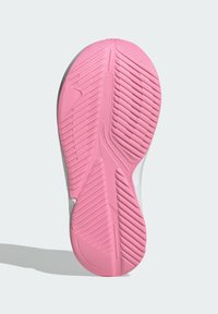 Suela de zapatilla de goma en color rosa con surcos de tracción multidireccional y diseño texturizado, que presenta un acento blanco liso en los laterales.