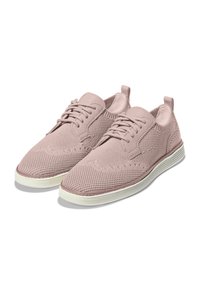 Zapatillas de malla rosa claro con parte superior texturizada y acentos de cuero suave. Presentan puntera redonda, cordones y suela de goma a rayas.