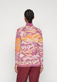 Long-sleeve pullover with high collar, featuring a pink, orange, and purple mountain pattern, made from a textured knit fabric.