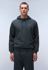 Donkergroene hoodie gemaakt van zachte stof, met een kangoeroezak, geribde manchetten en een klein logo op de borst.