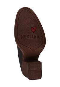 Suela de zapato marrón con superficie texturizada. Presenta la inscripción "MUSTANG", un icono de corazón rojo y la talla "36" en relieve. Bordes lisos y talón reforzado.
