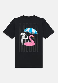 Svart t-skjorte med grafikk av en rosa flamingo-float, en hvit plaststol og en blåstripet paraply. Designet er fargerikt og lekent.