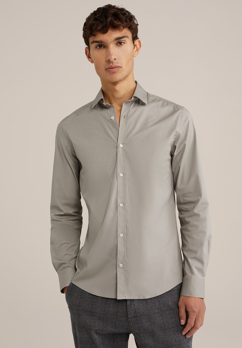 Chemise boutonnée gris clair à manches longues, coupe ajustée et texture lisse. Caractéristiques d'un col cranté et de boutons blancs.