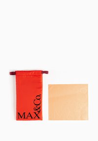 Pungă din satin roșu cu șnur, având text negru "MAX&Co." lângă o bucată de țesătură bej cu text "MAX&Co." embosat.