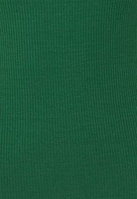 Grön ribbad textil med en slät, strukturerad yta som har vertikala linjer som skapar ett konsekvent mönster över tyget.