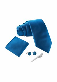 Cravate texturée bleue, pochette assortie, boutons de manchette ronds bleus et pince à cravate en argent, tous présentés sur un fond blanc.