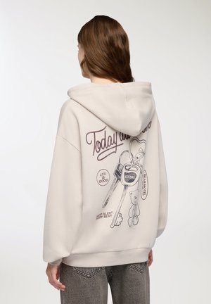 Felpa beige con tasca a marsupio. Il design grafico sulla schiena presenta chiavi, un orsacchiotto e testo. Realizzata in tessuto morbido; vestibilità comoda.