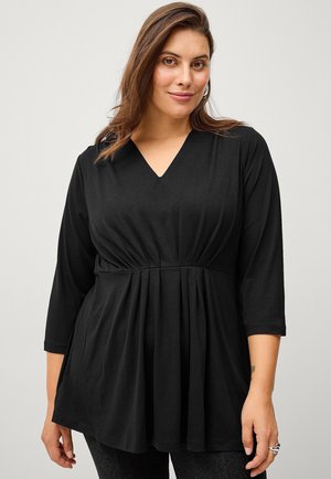 Black V-neck tunic top with three-quarter sleeves, featuring a gathered waist design and a flowing hemline. Made from soft, lightweight fabric.