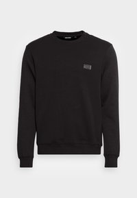 Felpa nera realizzata in misto cotone, con collo a giro, maniche lunghe e una piccola etichetta con logo sul petto. Texture liscia, design casual.