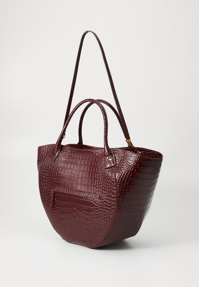Τσάντα tote σε μπορντό χρώμα με σχέδιο κροκοδείλου, διαθέτει διπλές λαβές και ρυθμιζόμενο λουρί ώμου. Περιλαμβάνει μπροστινή τσέπη και γυαλιστερή υφή.