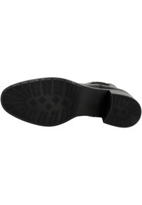 Suela de bota negra con goma texturizada, que presenta un diseño de agarre estampado y un talón reforzado para mayor durabilidad. Acabado suave en los bordes.