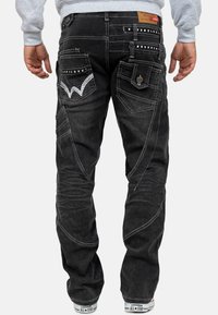 Jeans in denim nero con cuciture a vista, multiple tasche e dettagli decorativi sulle tasche posteriori. Design aderente, forma a gamba dritta.