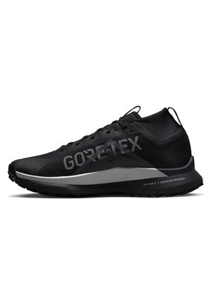 Schwarzer Gore-Tex Laufschuh mit hohem Knöchelkragen, strukturierter Sohle und reflektierenden Details an der Zwischensohle und am oberen Bereich.