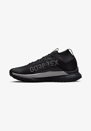 Chaussure de running Gore-Tex noire avec col montant à la cheville, semelle texturée et détails réfléchissants sur la semelle intermédiaire et la partie supérieure.