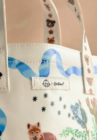Canvas tote taske med dyreillustrationer i forskellige farver. Blød hvid baggrund med blåt bånddesign og et logotag.