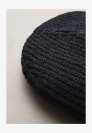 Tamno pletena beretka s rebrastom teksturom, izrađena od vune, ovalnog oblika i od debelog, mekanog platna. Nema vidljivih ukrasa ili uzoraka.