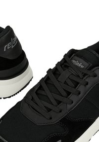 Schwarze Sneakers aus einer Kombination von glattem Leder und strukturiertem Stoff. Enthält Schnürsenkel, ein Logo und eine weiße Zwischensohle mit griffiger Außensohle.