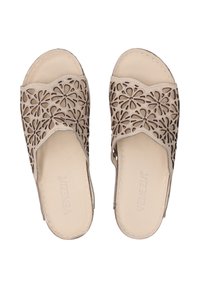 Beige instapsandalen met een bloemen uitsnijding ontwerp, zachte binnenvoering en gestikte randen. Open achterkant met een ronde neus.