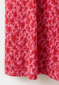 Tissu plissé floral rouge et rose avec de petits motifs floraux denses et un ourlet cousu en bas.