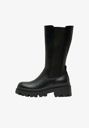 Botte noire en cuir jusqu'au genou avec des panneaux élastiques sur les côtés, semelle épaisse crantée et bout arrondi. Fini lisse avec une texture mate.